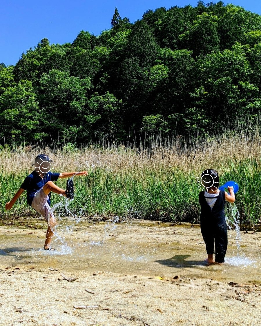 元の写真:小川で水遊びをする2人(顔はスタンプで隠しています)